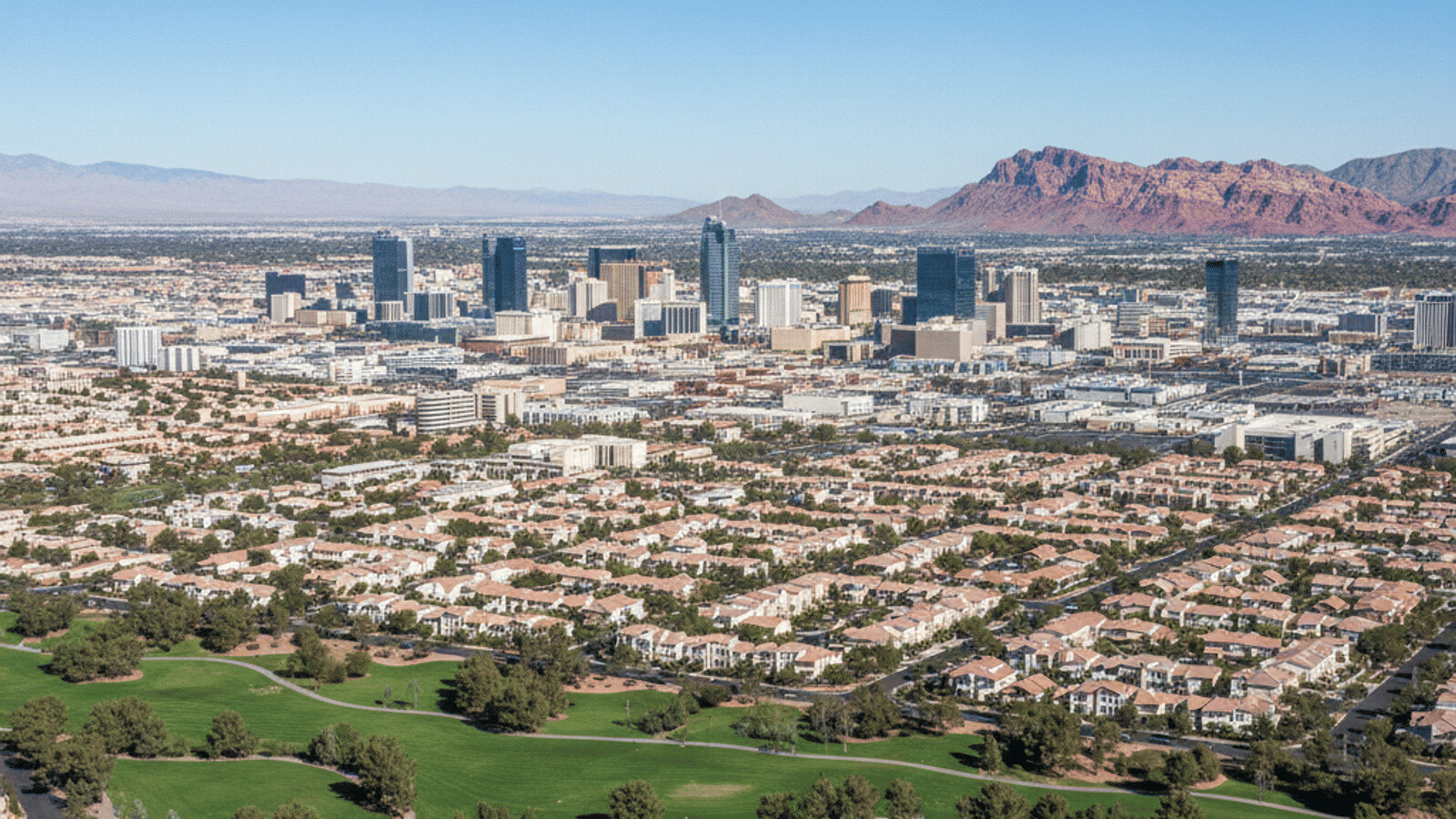 Typical Las Vegas single-family suburban neighborhood with tile-roof homes and desert landscaping under a blue sky